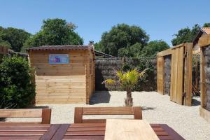滨海苏拉克Le Chai de l'Océan - Studio的一个带木棚和两个长凳的花园