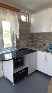 乌雷基Cottage Teremok 7 people的厨房配有白色橱柜和炉灶烤箱。