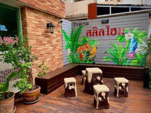 曼谷Salin Home Hotel Ramkhamhaeng的种植了植物的庭院和带壁画的墙壁