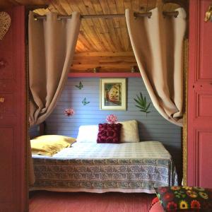 耶尔Roulotte Fenouillet的一间带床的卧室,位于带窗帘的房间