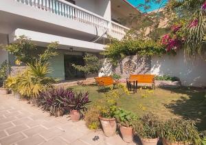 卡拉奇Hype Holiday Homes的楼前有长椅和植物的庭院