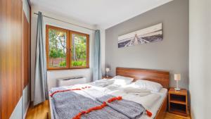 加茨比亚格拉Apartamenty Sun & Snow Villa Cztery Pory Roku的一间卧室设有一张床和一个窗口