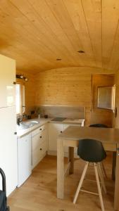 勒瓦德约尔Rigoulotte的厨房设有木制天花板和木桌。