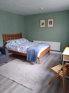 卡里克马克罗斯Rock House的卧室设有一张位于绿色墙壁上的床铺