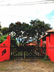 佩尼多Sitio148 Hospedaria的房屋前有红色门的木栅栏