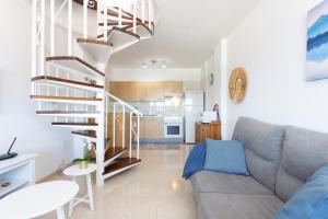 圭马尔港Home2Book Sea Front Duplex Terrace Pool的带沙发和螺旋楼梯的客厅