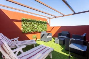圭马尔港Home2Book Sea Front Duplex Terrace Pool的庭院设有椅子和种植了植物的墙壁