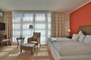 萨尔斯塔特古德库克酒店的一间卧室配有一张床、一把椅子和一张书桌