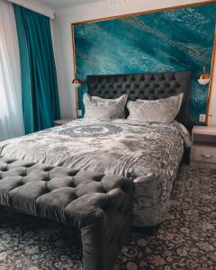 布什泰尼Suru Hotel & Restaurant的一间卧室配有一张大床和大床头板