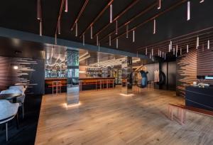 韦尔米廖阿尔福斯木屋酒店的餐厅设有酒吧,配有木地板和吊灯