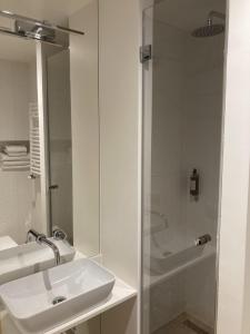 比亚韦斯托克薇拉帕斯特尔别墅酒店的白色的浴室设有水槽和淋浴。