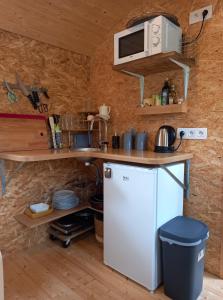 FloreffeLa Roulotte Viticole - sauna - toilette sèche的小厨房配有冰箱和微波炉。