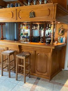 索非亚Family Hotel Zdravets的一间木酒吧,在房间内配有两张凳子