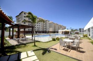 伊列乌斯Apartamento em Ilhéus próximo as Praias的一个带桌椅的庭院和一个游泳池