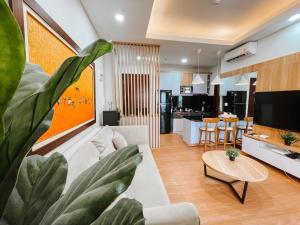 雅加达2 Bedrooms Permata Hijau Suites Apartment的客厅配有白色沙发和大植物