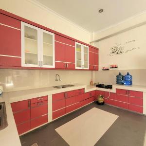 巴东Mahakam Guest House的一间带红色橱柜和水槽的厨房