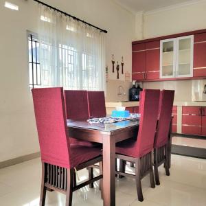 巴东Mahakam Guest House的厨房配有木桌和红色椅子