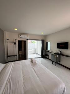 Ban Tha Phaesee-on place/สีอ่อนเพลส的卧室配有一张白色大床和电视。