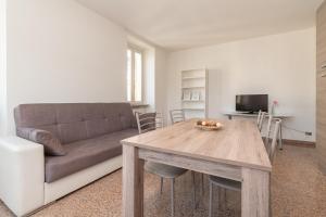 布雷西亚Appartamento Piazza Garibaldi - F&L Apartment的带沙发和木桌的客厅