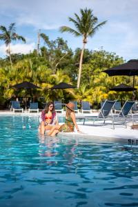 马拉松香蕉湾滨海度假酒店的两个女人坐在游泳池的水里