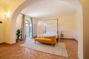皮恩扎Palazzo Massaini - La Pieve的一间卧室配有天蓬床和黄色椅子