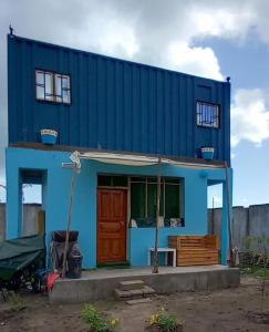 达累斯萨拉姆Beach House in Kigamboni Dar es Salaam的前面有一道红色门的蓝色房子