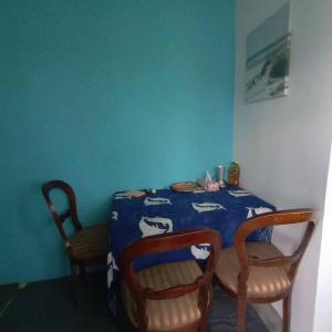 达累斯萨拉姆Beach House in Kigamboni Dar es Salaam的一张带两把椅子的餐桌和蓝色的墙壁