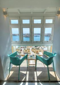 瓦莱塔Spacious maisonette with spectacular views IBRI1-1的带窗户的客房内配有两把椅子和一张桌子