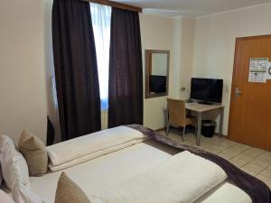 施瓦尔姆塔尔拉特酒店的一间卧室设有两张床、一张桌子和一个窗口。