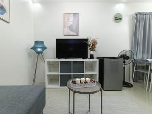 马比尼Manzil Anilao B&B的客厅配有电视和一张带鸡蛋的桌子。