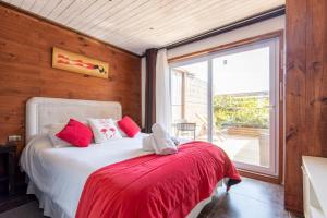 皮奇勒姆Pichilemu Apart Hotel的一间卧室配有一张带红色毯子的床和窗户。