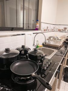 CarazApart La Merced的厨房配有带水槽的炉灶和2个锅