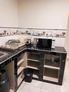 CarazApart La Merced的厨房配有带微波炉的黑色台面