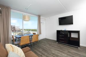 威尔伍德克拉斯特奥岛海滩度假酒店的客厅设有餐桌和电视