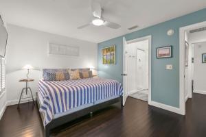 圣奥古斯丁Weeden Cottage的一间拥有蓝色墙壁的卧室和一张带条纹毯子的床