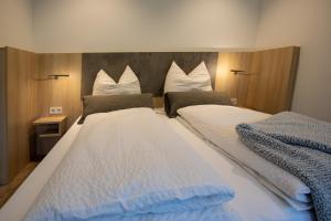 赫斯巴赫Livin63 Studio Apartments的一间卧室配有两张带白色和蓝色床单的床