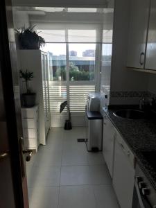 维戈Apartamento Conchita的一间厨房,配有白色的橱柜和大窗户