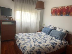 维戈Apartamento Conchita的一间卧室配有一张带蓝白色毯子的床