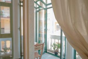 萨莱诺Maga Mirò - Guest House的阳台设有玻璃门和木凳