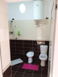 克鲁亚Meti Guest House的浴室设有卫生间和带粉红色垫的淋浴。