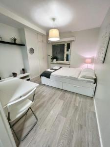 赫尔辛基Charming Central Apartment Helsinki的白色卧室配有床和书桌