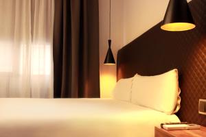 马德里马德里乌胡套房旅馆的卧室配有白色的床和窗户。