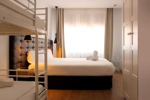 马德里马德里乌胡套房旅馆的一间卧室设有两张双层床和一扇窗户。