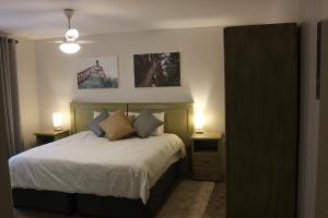 SimunyeLivivane Guest House的一间卧室配有一张带2个床头柜和2盏灯的床。