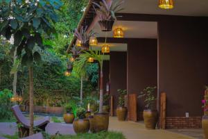 蒂安瓜Muda Hotel的大堂设有盆栽和吊灯