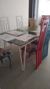 卡波布里奥Apartamento à beira mar Praia de Unamar的一张桌子、两把椅子和一张桌子及桌椅