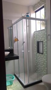 卡波布里奥Apartamento à beira mar Praia de Unamar的浴室内带玻璃淋浴间