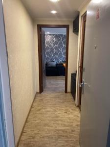 第比利斯Luxury Apartment in Tbilisi City Centre的走廊通往带沙发的客厅