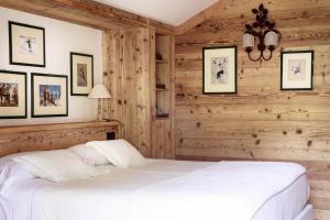 库马约尔Auberge de La Maison的卧室设有白色的床和木墙
