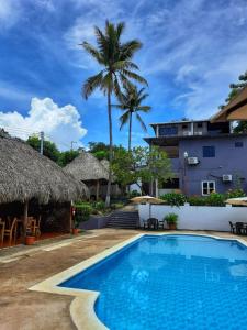 拉利伯塔德Hotel Tunco Lodge的棕榈树度假村的游泳池以及大楼
